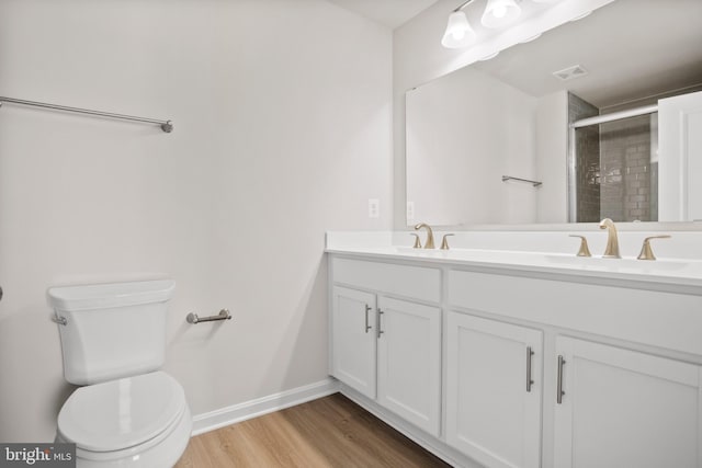 bathroom featuring an enclosed shower, vanity, toilet, and wood-type flooring