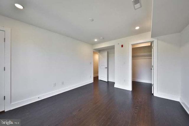 unfurnished bedroom with dark wood-type flooring and a closet