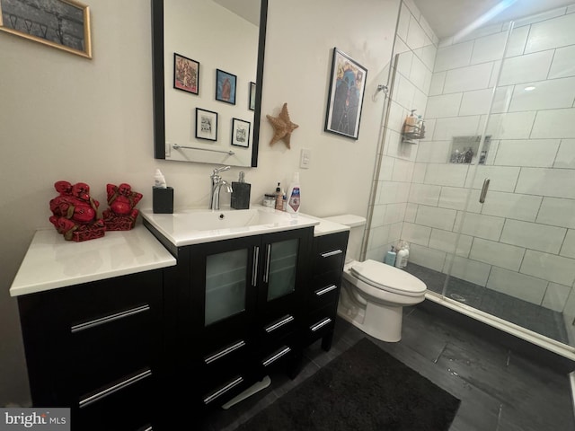 bathroom with vanity, toilet, and a shower with door