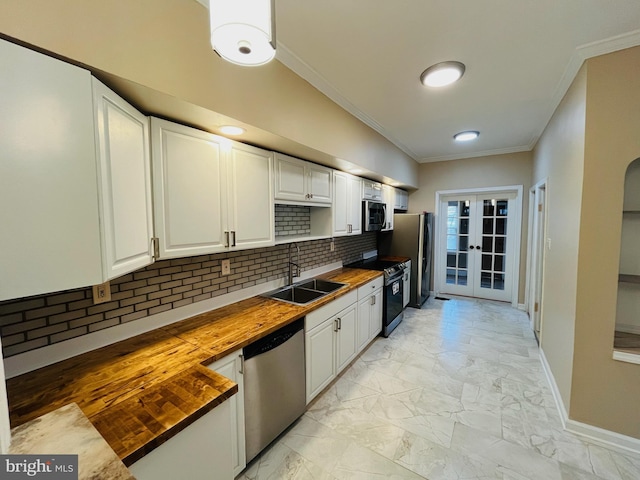 kitchen featuring wooden counters, stainless steel appliances, french doors, white cabinets, and sink