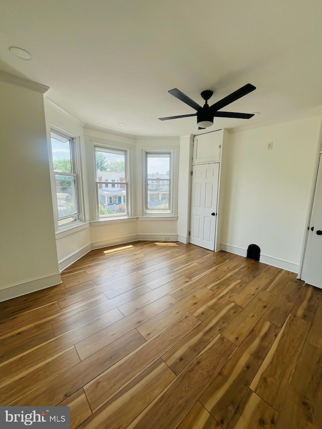 spare room with ceiling fan, crown molding, and hardwood / wood-style flooring