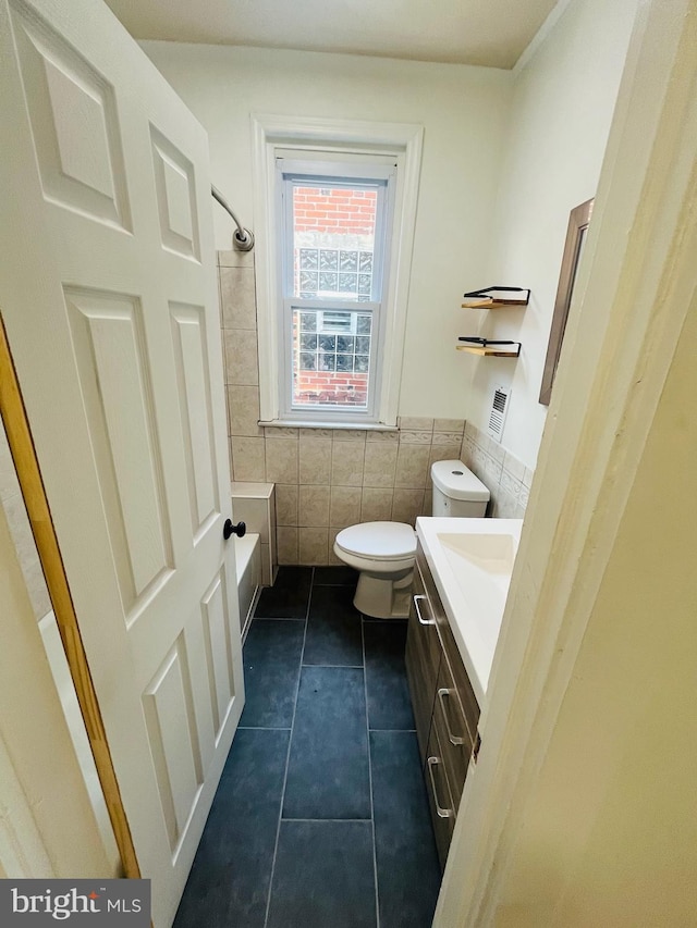 bathroom with tile walls, tile patterned floors, vanity, and toilet