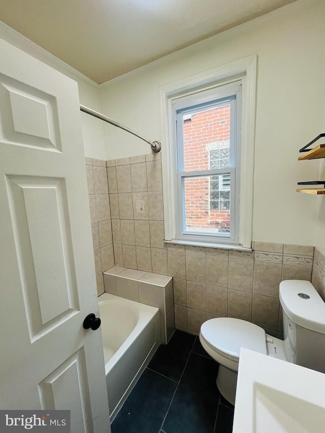 bathroom with tile walls, toilet, and tile patterned flooring