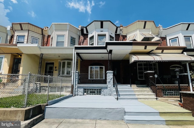 townhome / multi-family property featuring covered porch