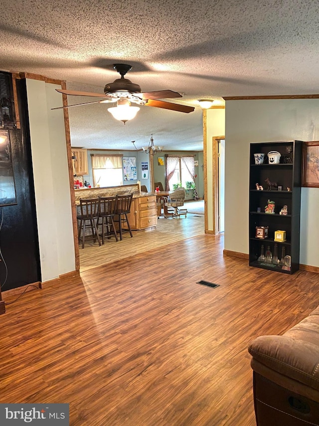 living room with ceiling fan, wood-type flooring, and a textured ceiling