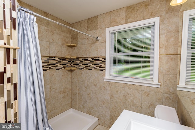 bathroom with a shower with shower curtain and toilet