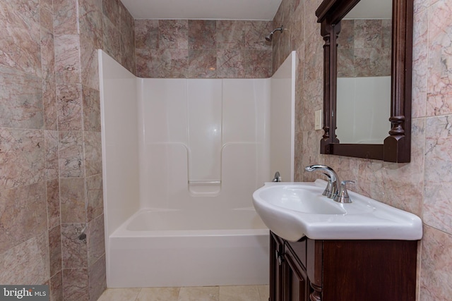 bathroom with bathtub / shower combination, vanity, tile walls, and tile patterned flooring