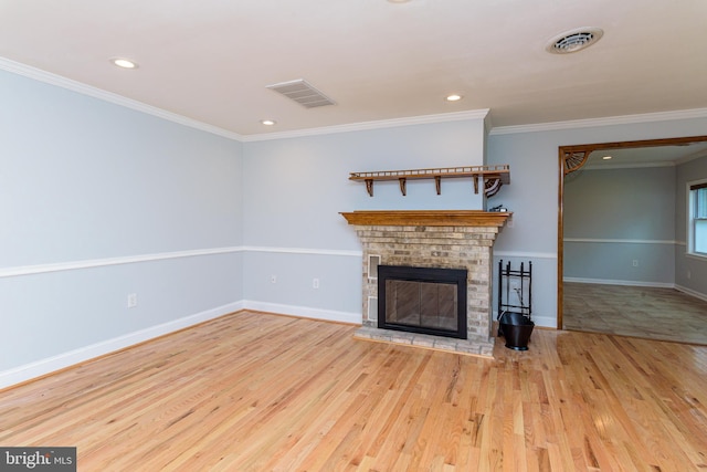 unfurnished living room with light hardwood / wood-style flooring, ornamental molding, and a brick fireplace