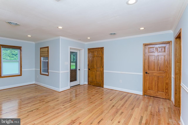 spare room featuring crown molding and light hardwood / wood-style floors