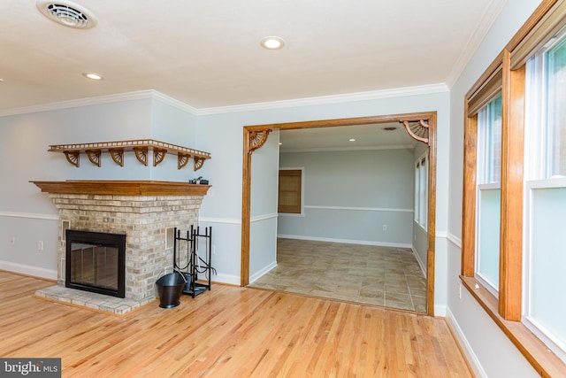 unfurnished living room featuring light wood-type flooring, a brick fireplace, and ornamental molding