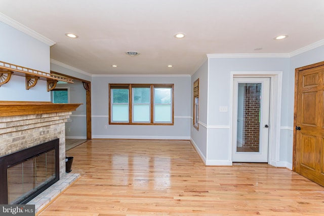 unfurnished living room featuring crown molding, a fireplace, and light hardwood / wood-style floors