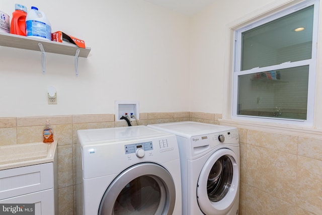 laundry area featuring washing machine and dryer and tile walls