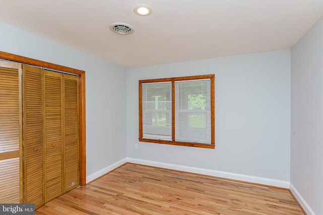 unfurnished bedroom featuring a closet and light hardwood / wood-style floors