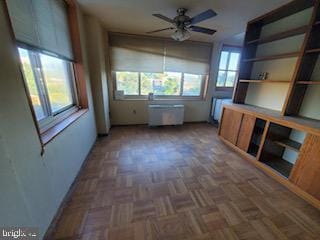 interior space with radiator, dark parquet floors, and ceiling fan