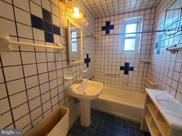 bathroom featuring tile patterned flooring, tiled shower / bath combo, and tile walls