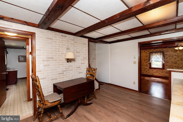 dining area with wood-type flooring and beam ceiling