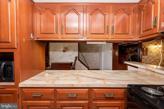 kitchen with black electric range oven and backsplash