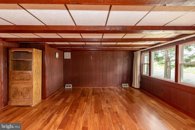 unfurnished room with hardwood / wood-style flooring and wood walls