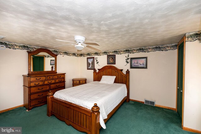 unfurnished bedroom with ceiling fan, dark carpet, and a textured ceiling