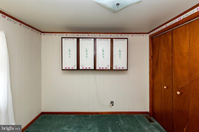 unfurnished bedroom featuring a closet and dark colored carpet