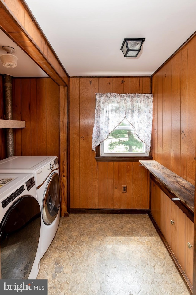 laundry room with washing machine and dryer and wood walls