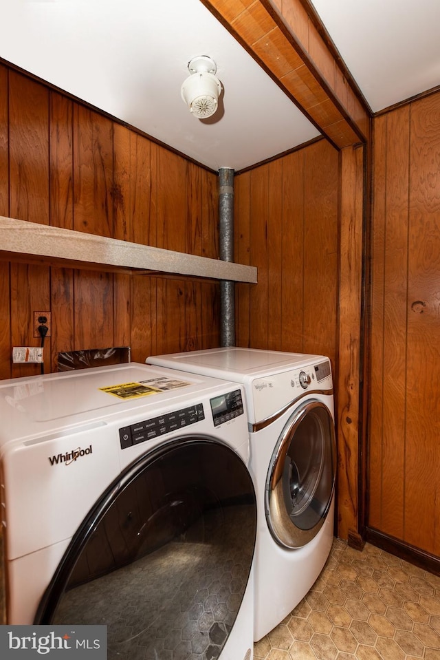 laundry area featuring wooden walls and washing machine and dryer