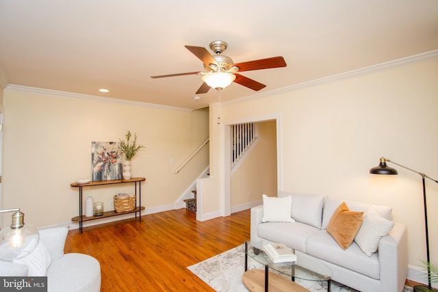 living room featuring hardwood / wood-style flooring, ornamental molding, and ceiling fan