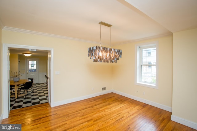 dining area with ornamental molding, hardwood / wood-style flooring, and a notable chandelier