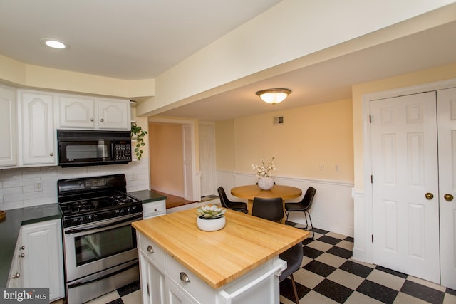 kitchen with white cabinets, backsplash, stainless steel gas stove, and a center island