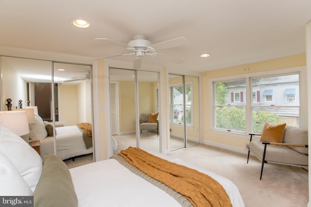 carpeted bedroom with ceiling fan and multiple closets