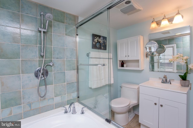 bathroom with toilet, vanity, and a shower with door