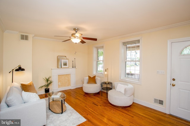 living room with ceiling fan, crown molding, and hardwood / wood-style floors