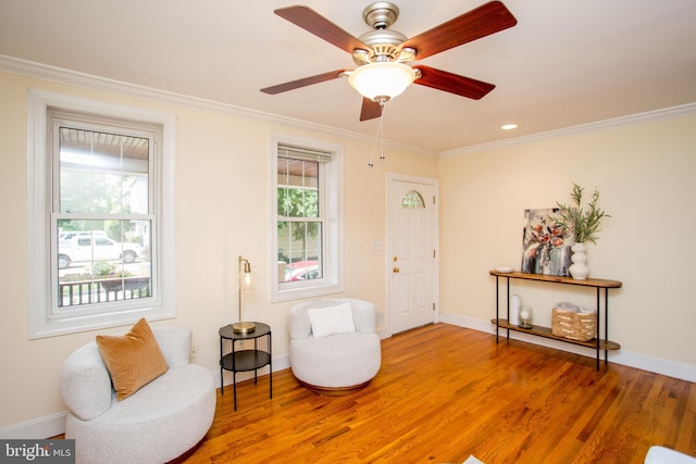 sitting room with ceiling fan, crown molding, and hardwood / wood-style floors