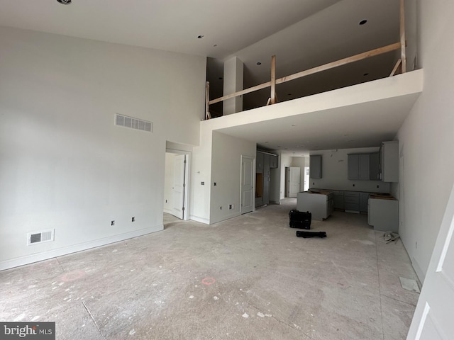 unfurnished living room with a high ceiling