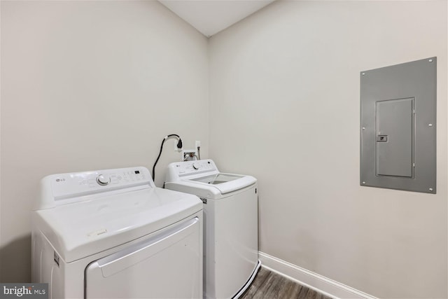 washroom featuring electric panel, dark wood-type flooring, and washing machine and clothes dryer