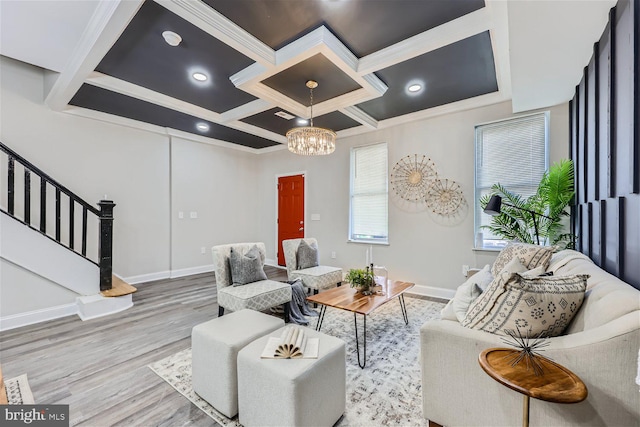 living room featuring light wood-type flooring, a notable chandelier, crown molding, and coffered ceiling