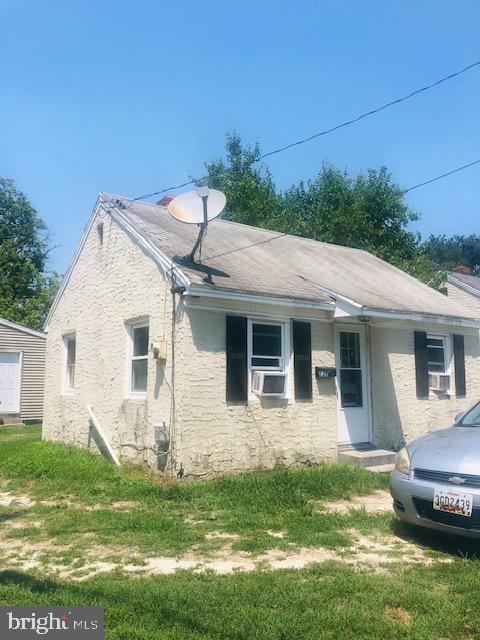 view of front of property featuring a front yard and cooling unit