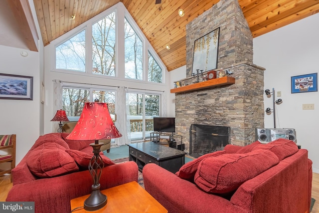 living room featuring a stone fireplace, wooden ceiling, and high vaulted ceiling