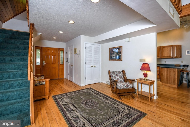 foyer with a textured ceiling and light hardwood / wood-style floors