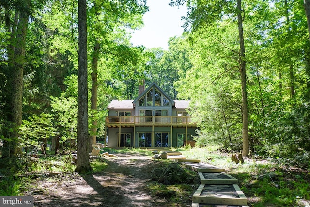 rear view of house featuring a wooden deck