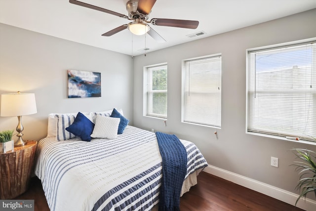 bedroom with dark hardwood / wood-style flooring and ceiling fan