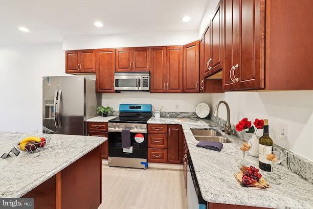 kitchen featuring light stone counters, sink, and stainless steel appliances