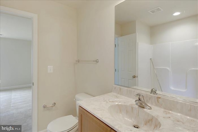 bathroom with a shower, vanity, and toilet