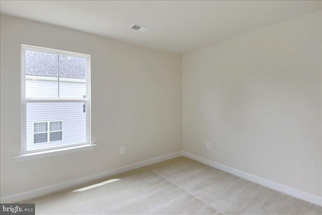 spare room featuring light carpet