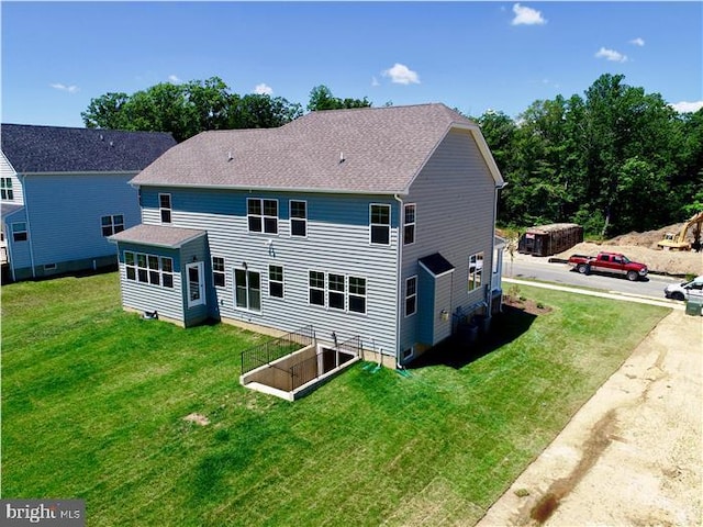 rear view of property featuring a lawn