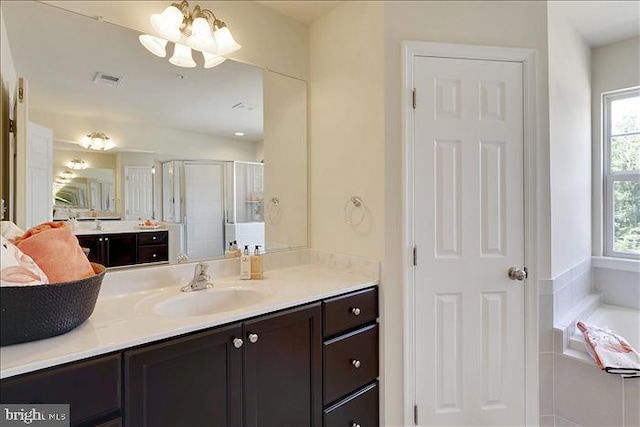 bathroom featuring vanity, shower with separate bathtub, and an inviting chandelier