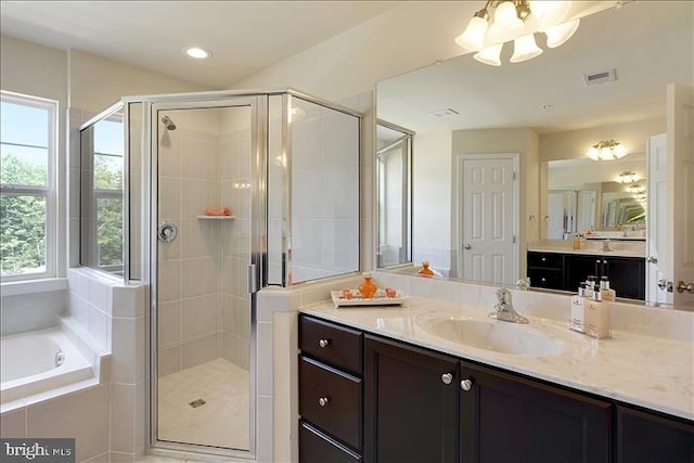 bathroom with vanity, separate shower and tub, and a chandelier