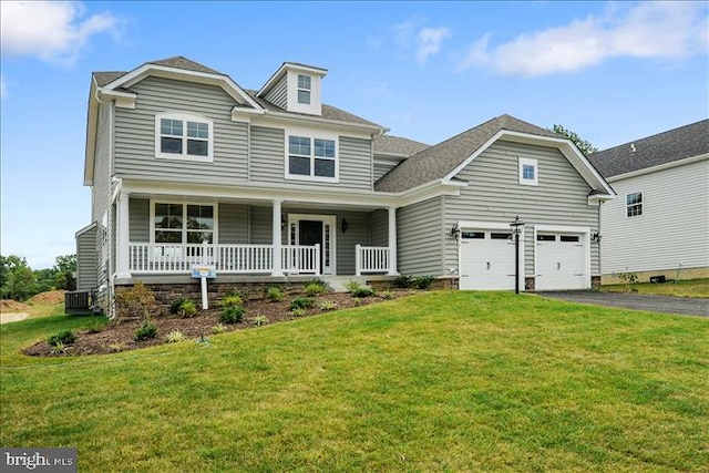 view of front of house with a garage, covered porch, and a front lawn