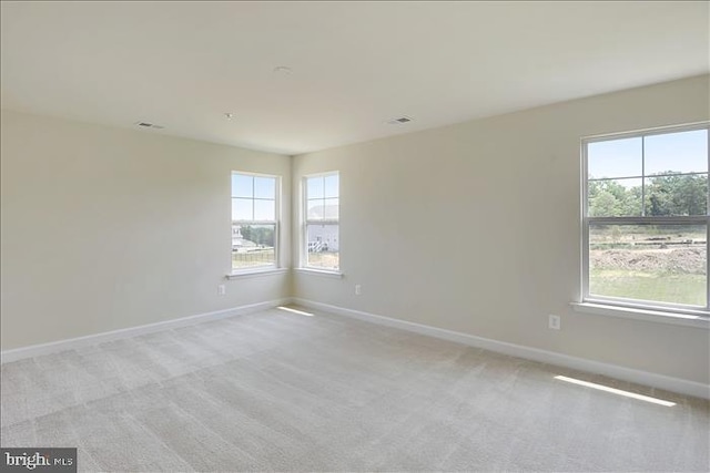 unfurnished room featuring light carpet