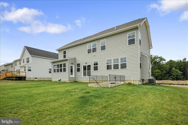 rear view of house featuring central AC, a yard, and a wooden deck